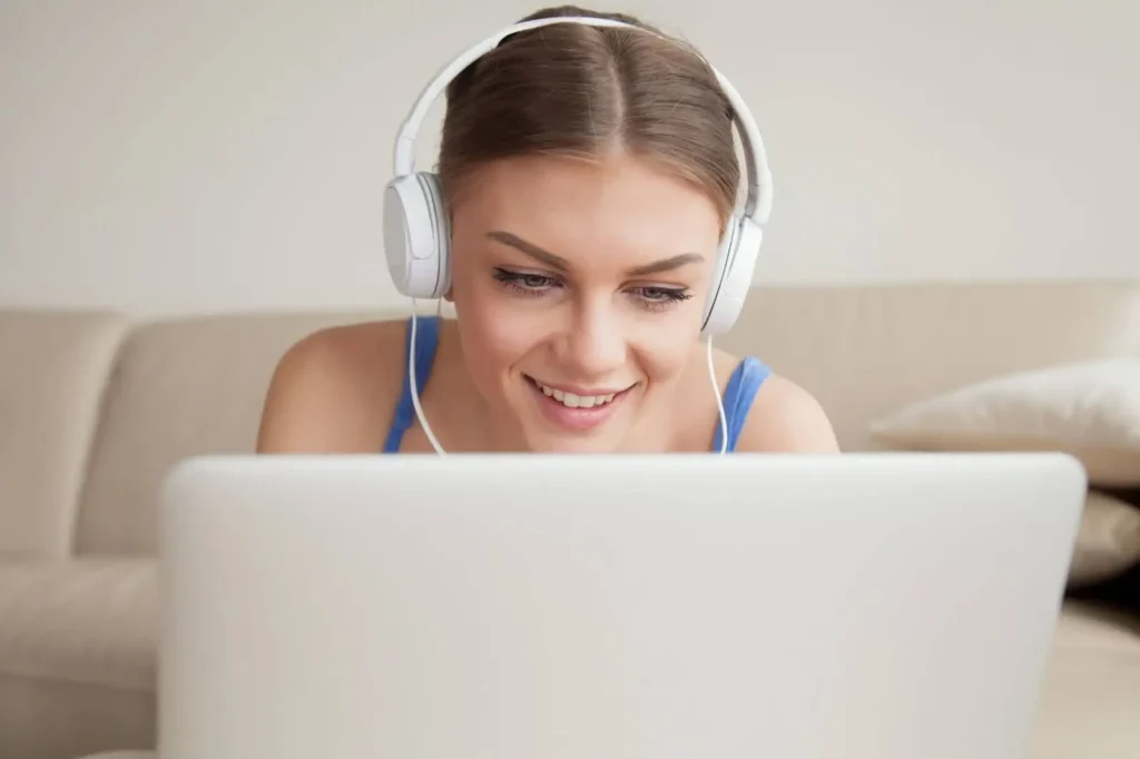 Young woman with headphones taking online Dutch lessons.