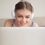 Young woman with headphones taking online Dutch lessons.