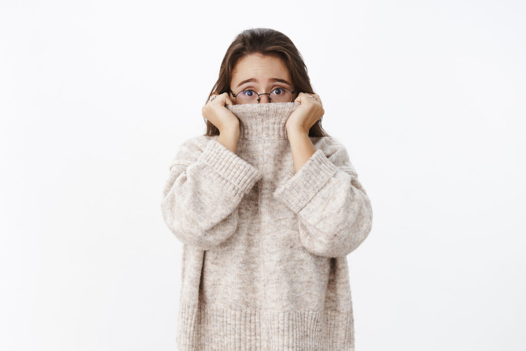 Woman who's afraid to speak Dutch, hiding in her turtleneck.