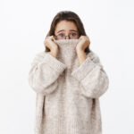 Woman who's afraid to speak Dutch, hiding in her turtleneck.