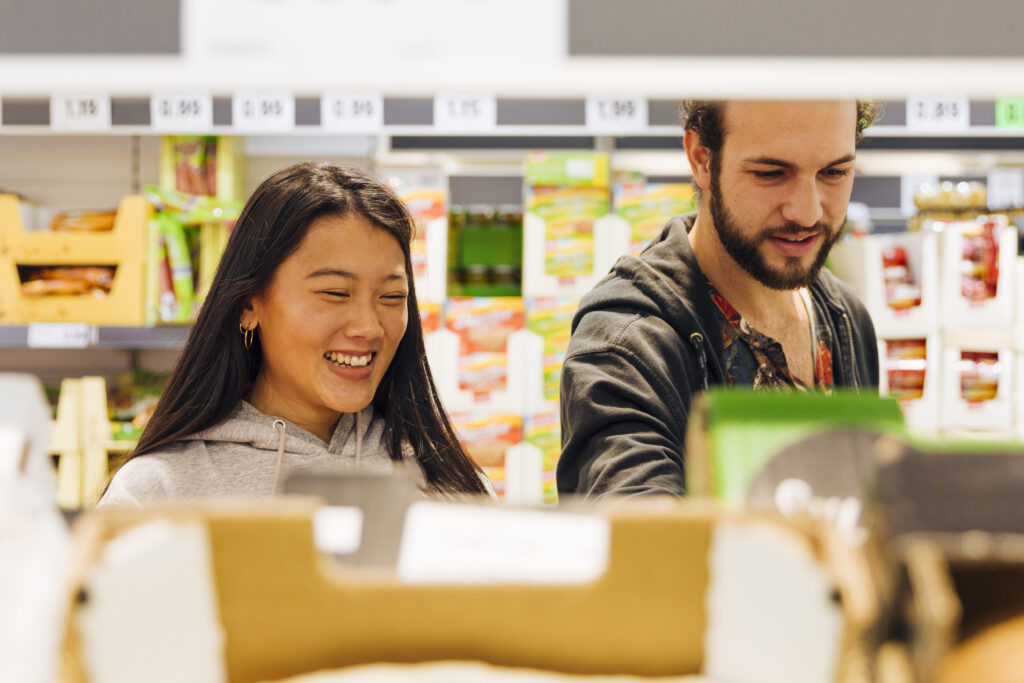 Young people having a chat in a supermarket. Start with small steps when you want to get rid of your fear of speaking Dutch.